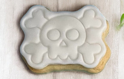 Skull & Cross Bones Paint Your Own Cookie – skull and crossbones-shaped iced biscuit with edible paint palette and brush, fun and creative kids’ Halloween baking activity or party treat.
